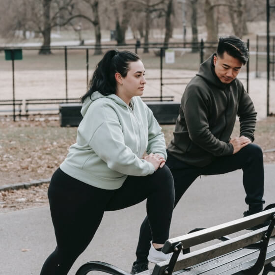 a man and woman stretching on a bench