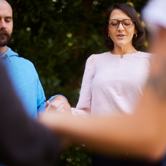 a woman with glasses standing in front of a man