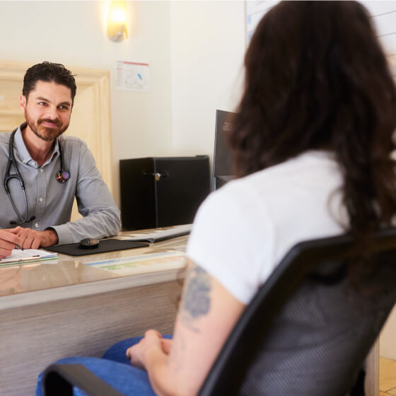 a man sitting at a desk with a stethoscope around his neck