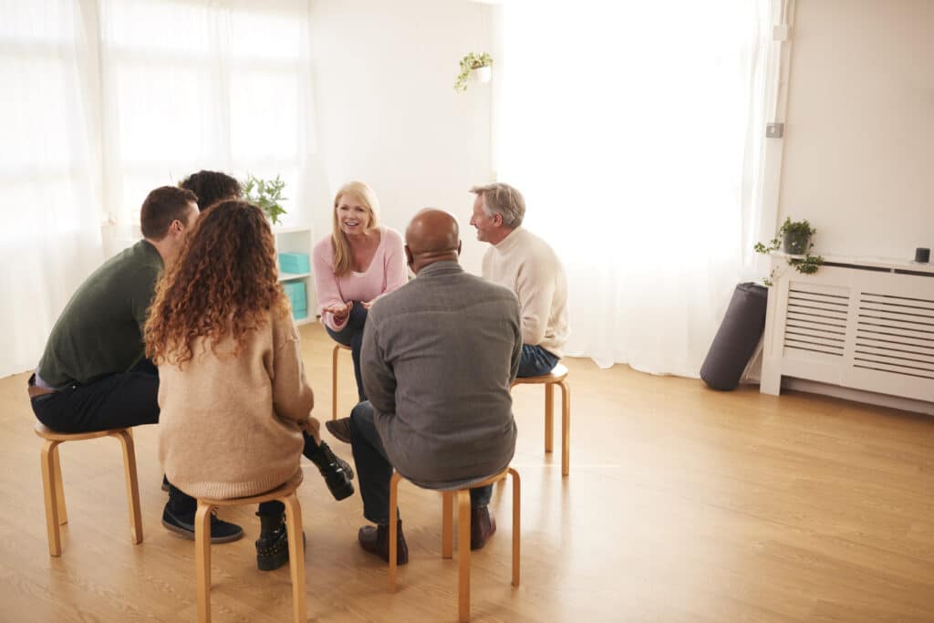 People Attending Support Group Meeting For Mental Health Or Dependency Issues In Community Space