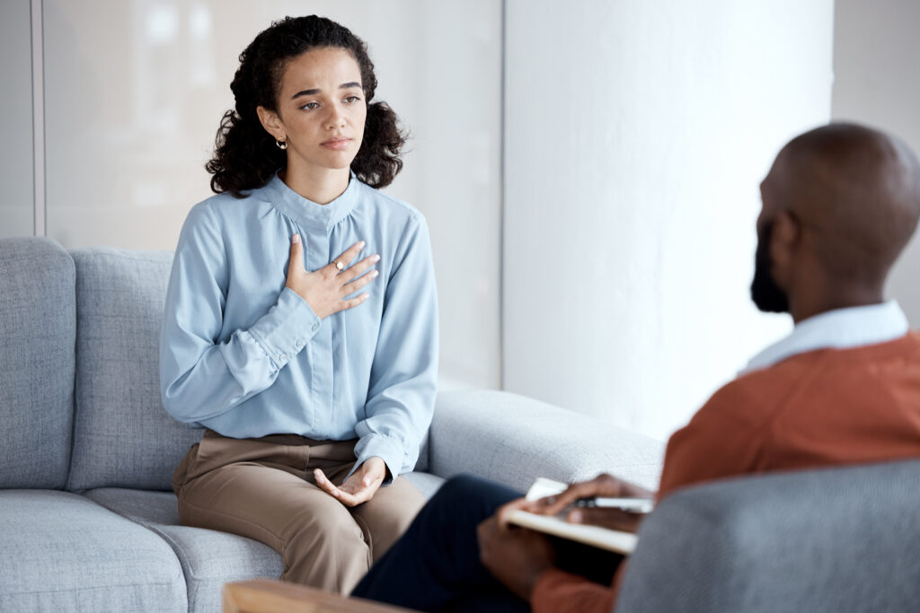 Conversation, sad and woman with a psychologist for therapy, trauma and mental health support. Cons.