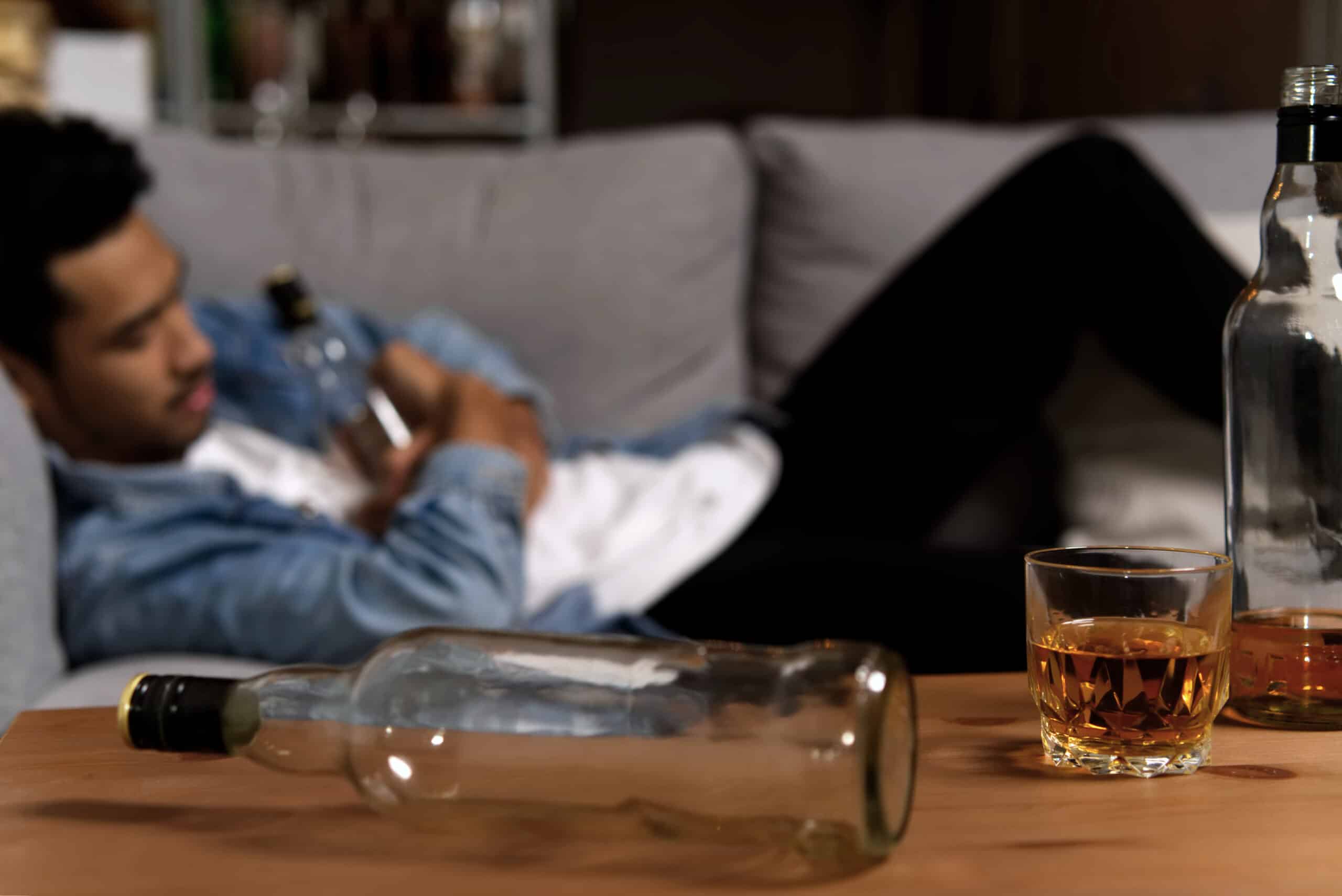 drunk man sleeping on sofa and holding bottle of w 2026 01 09 07 03 44 utc scaled