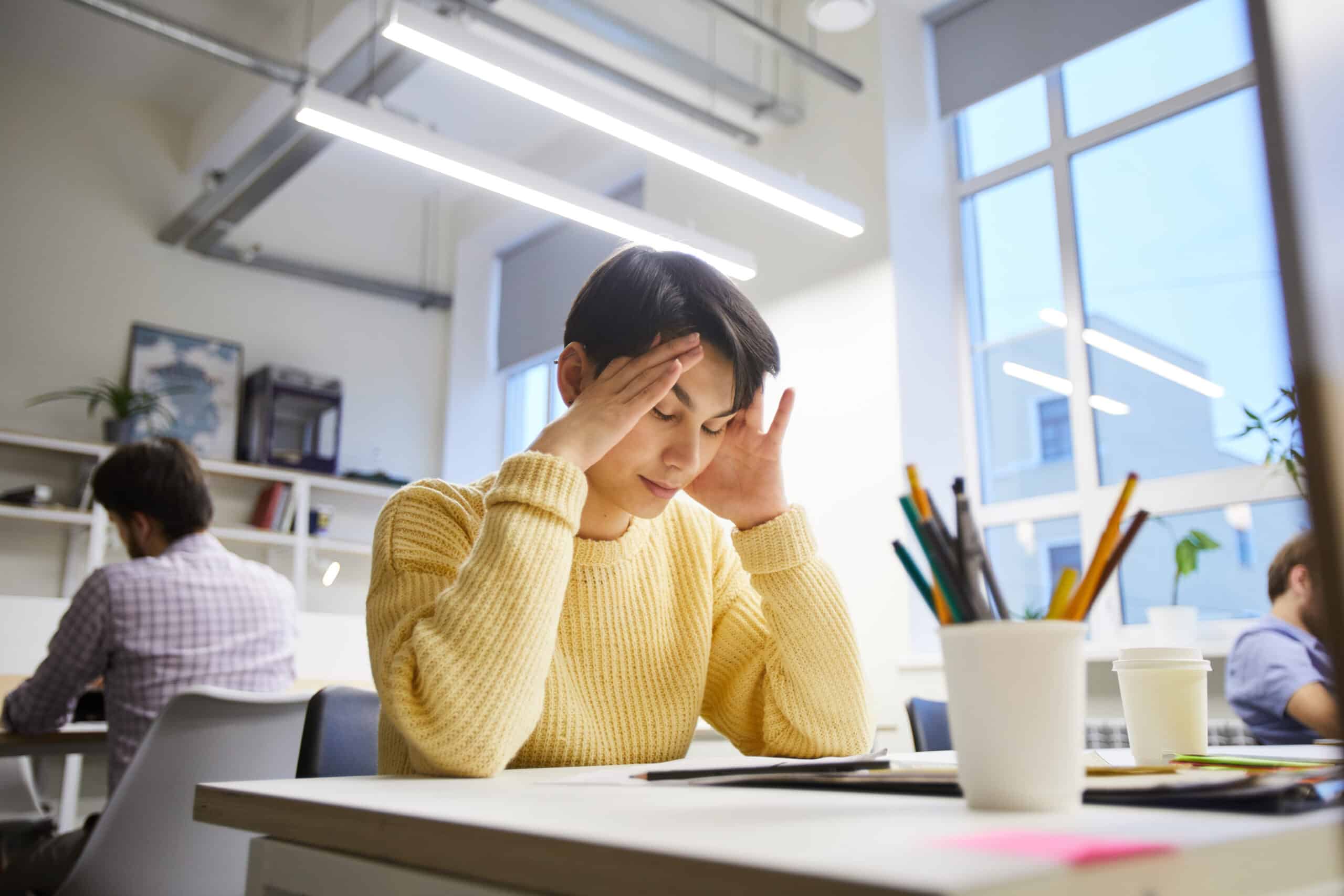 A woman looking stressed in an office wondering how long does lexapro stay in your system.